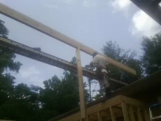 Carpenter setting a ridge beam over a new addition frame — Ice Dam Removal by Roofing Brothers in Merry Hill