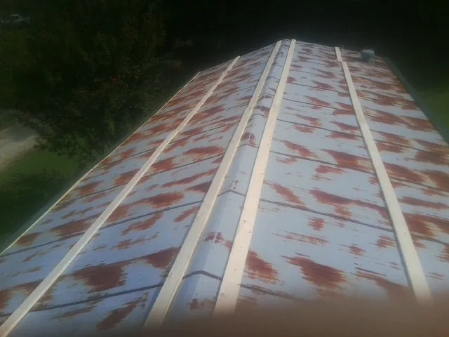 Rusted metal roof panels with new wood purlins before replacement — Storm Damage Roof Repair in Merry Hill by Roofing Brothers