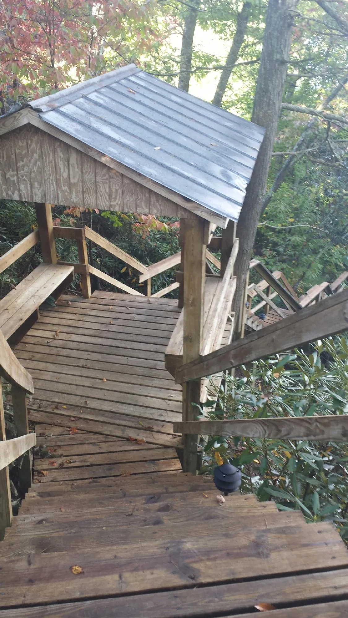 Metal roofed shelter over wooden steps on a wooded walkway — Skylight Repair & Installation work by our crew in Merry Hill