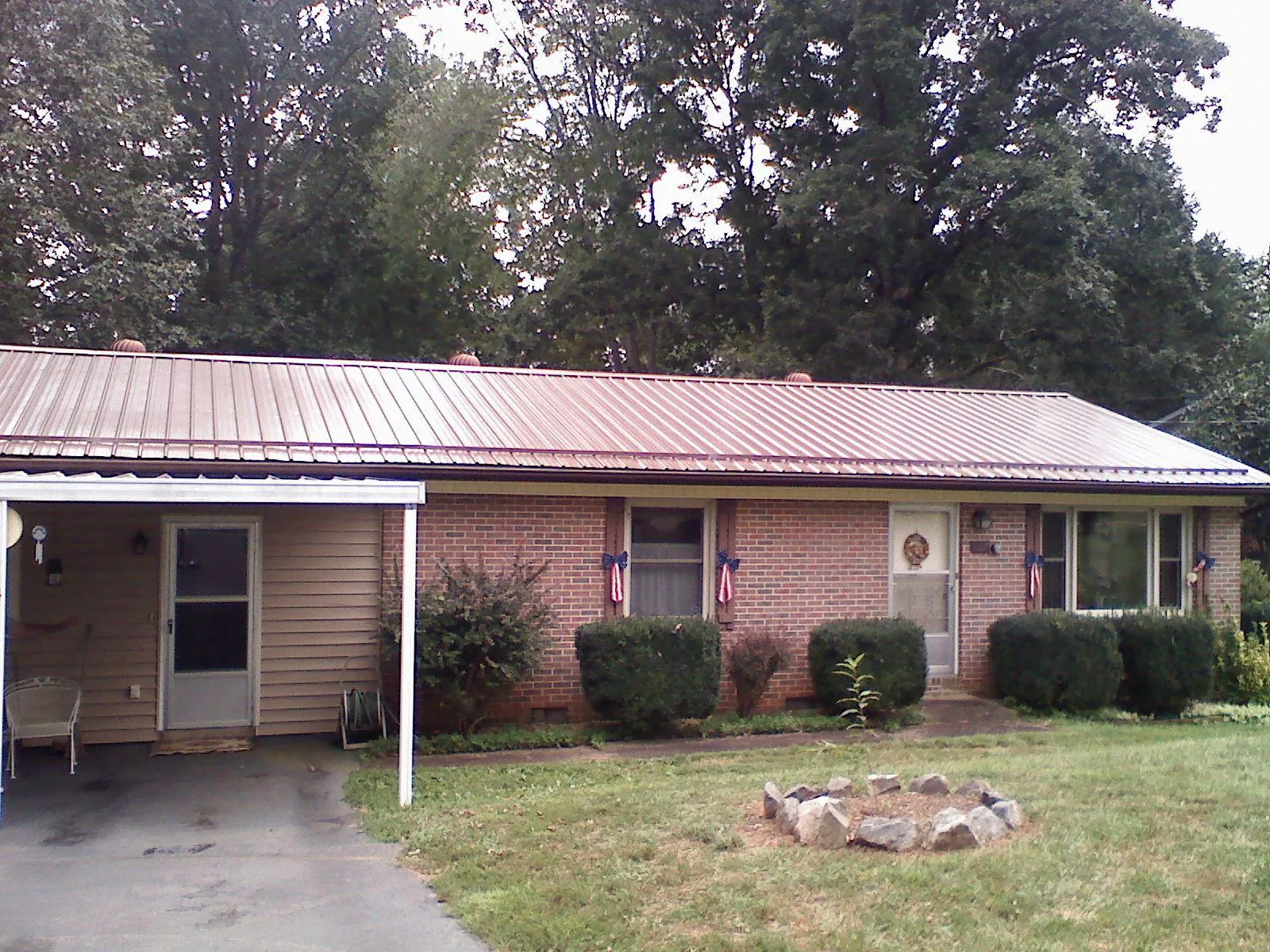 Bronze metal roof and carport on a brick ranch home — Roof Repair work by our crew in Merry Hill